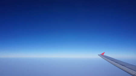 plane wing with horizontal skyline with no cloud. Space for copy spaceの写真素材