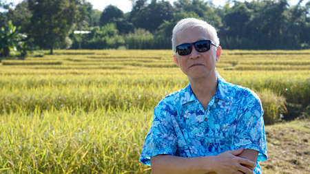 Asian guy in bright shirt at his SME farmland. Abstract own agricultural business