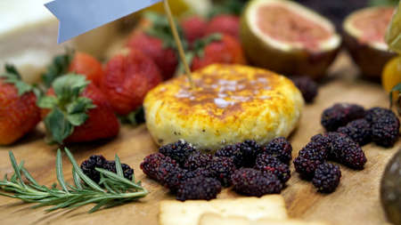 Cheese and assorted fruits on wood board. Healthy food setting backgroundの写真素材