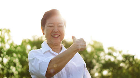 asian senior woman smile in sunshine and thumb upの写真素材
