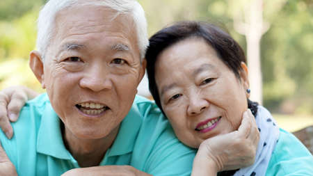 close up potrait of Asian senior couple on bright green background