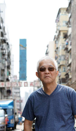 senior man with hong kong urban architecture scene. Travel to experience different placeの写真素材