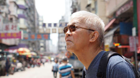 senior man with hong kong urban architecture scene. Travel to experience different placeの写真素材