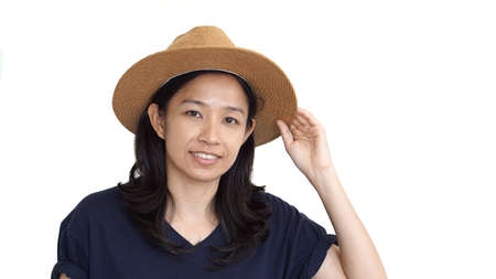 Casual friendly asian girl wearing hat relaxing and smiling on white backgroundの写真素材