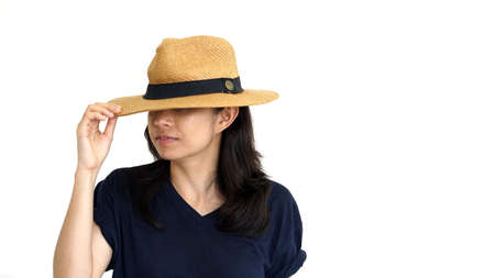 Asian girl hiding face under panama hat fear guilty conceptの写真素材