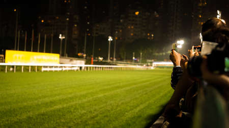 Crowd at horse race course edge cheering, taking photo and prepare for game gablingの写真素材