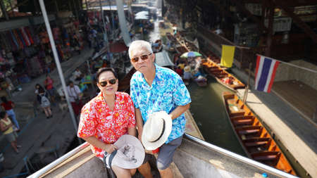 Asian senior couple having retirment trip to Thailand floating marketの写真素材