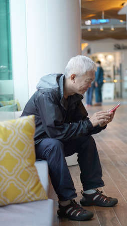 Asian senior man using smart phone. Communicate with family through technologyの写真素材