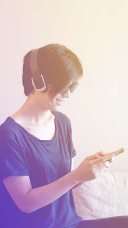 Asian cool hipster girl wearing sunglasses and headphone, urban lifestyle concept soft light pastelの写真素材