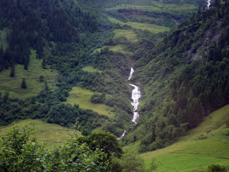Waterfall running through Europe road side mountain. Lush nature view の写真素材