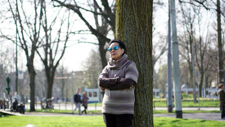 Asian senior woman travel in europe taking potrait in parkの写真素材