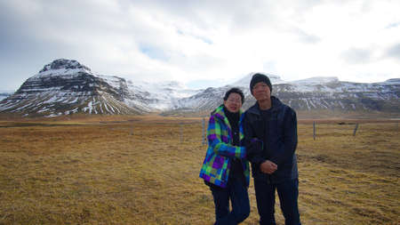 Asian senior couple enjoy anniversary trip in Europe. Iceland volcanic landscape mountain with snow amazing viewの写真素材