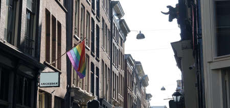 Rainbow flag, LGTB pride, hanging over building in Amsterdam, Netherlandsの写真素材