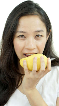 Asian beautiful woman eating posing with mango. Summer delight tropical fruit.の写真素材