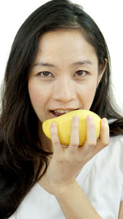 Asian beautiful woman eating posing with mango. Summer delight tropical fruit.の写真素材