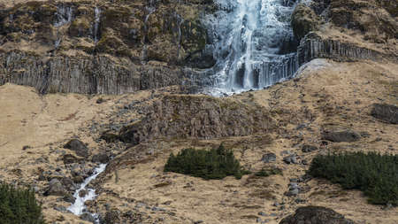 Majestic landscape, waterfall in Iceland. Half frozen melting after winterの写真素材