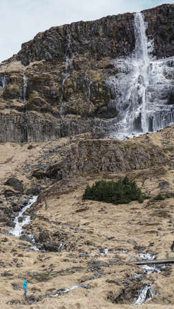 Man scale with majestic waterfall mountain size. How powerful nature is compare to humanの写真素材
