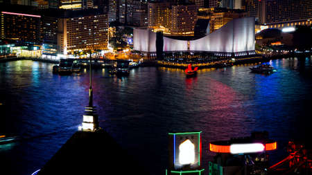 Hong Kong Victoria harbour and its iconic red ancient junk sail zoom shot from the Peak at nightの写真素材