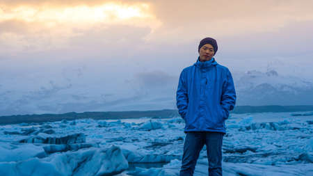 Asian man stand in front of million years old iceberg at glacier lagoon Icelandの写真素材