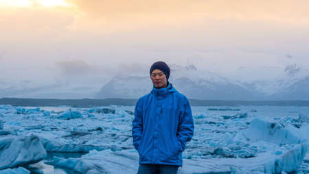 Asian man stand in front of million years old iceberg at glacier lagoon Icelandの写真素材
