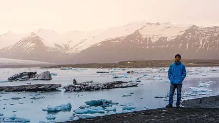 Asian traveler man standing in front of majestic beautiful landscape glacier lagoon of Icelandの写真素材