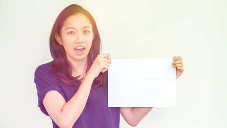 Casual beautiful Asian woman holding white sign with copy spaceの写真素材