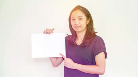 Casual beautiful Asian woman holding white sign with copy spaceの写真素材