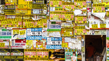 Wall texture cover full of yellow advertising flyer on abandoned building in Hong Kongのeditorial素材