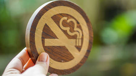 Hand holding wooden no smoking signの写真素材