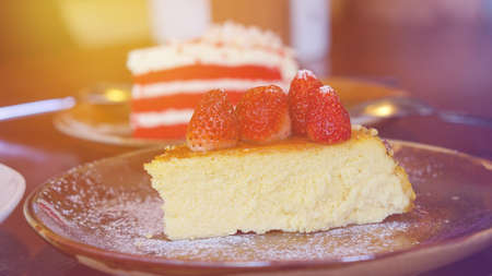 Slice of Cheesecake with strawberry and red velvet cake at cafeの写真素材