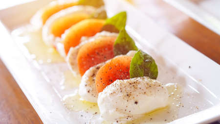 Mozzarella cheese serve with tomatoes and olive oilの写真素材