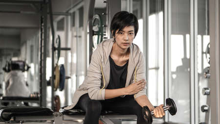 Smiling Asian short hair woman fitness dumbbell lifting. Healthy exerciseの写真素材