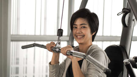 Asian woman fitness training machine smile faceの写真素材