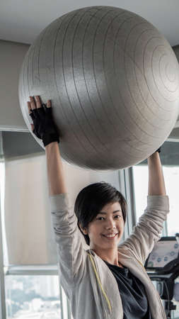 Asian woman short hair in sport fitness with yoga ball, healthy lifestyleの写真素材