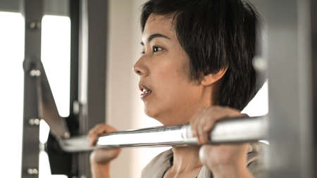 Asian woman fitness training machine smile faceの写真素材