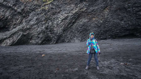 Asian senior woman having drean trip travel to Icealand, black beach