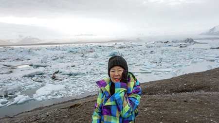 Asian old woman happy at Jokulsarlon glacier lagoon, Icelandの写真素材