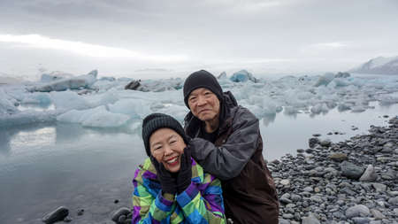Asian senior couple fun trip in Iceland, majestic glacier lagoon landscapeの写真素材