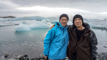 Asian son taking father to Iceland trip to see glacier lagoonの写真素材