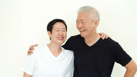 Asian senior couple smile together life with no worry on white backgroundの写真素材