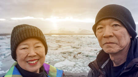 Asian senior couple fun trip in Iceland, majestic glacier lagoon landscapeの写真素材