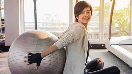 Asian woman short hair in sport fitness with yoga ball, healthy lifestyleの写真素材