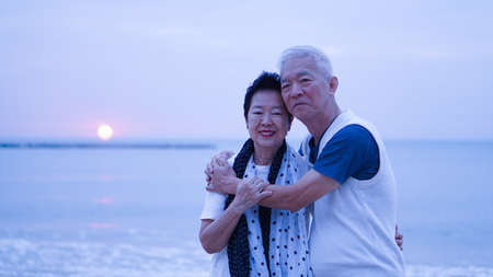 Asian senior couple morning date at sunrise sea