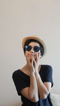 Cool sporty woman wearing sunglasses and hat facial expressionの写真素材