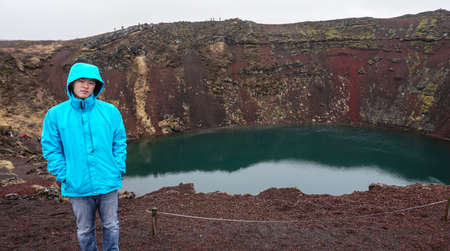 Asian man and volcano crater hole in Icelandの写真素材