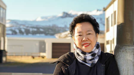 Asian senior woman portrait in Europe mountain village moring sunの写真素材