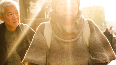 Asian senior couple travel in Europe tried walking in morning sunlightの写真素材