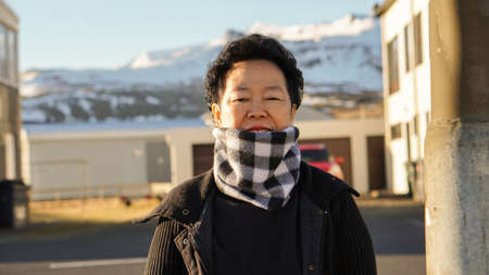Asian senior woman portrait in Europe mountain village moring sunの写真素材