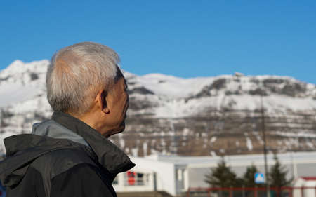 Asian man portrait with Europe snow mountain village background