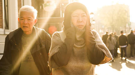 Asian senior couple travel in Europe tried walking in morning sunlight